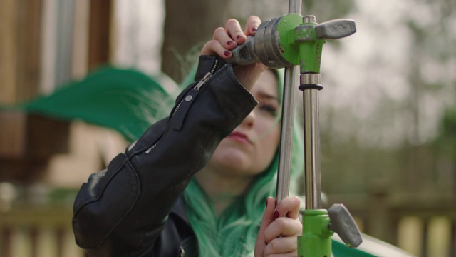 SLO MO:在电影设置中，绿色头发的女性握把C台的gobo手臂拉得更紧。视频素材