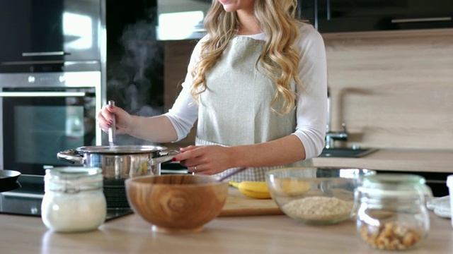 金发女人在厨房做早餐燕麦粥视频下载