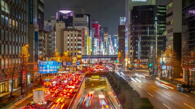 4K时间推移-缩小道路交叉口在晚上与交通堵塞附近的新桥车站-日本东京视频素材