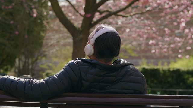 一个在公园里听音乐的成熟男人视频素材