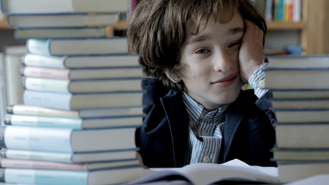 可爱的男孩在图书馆看书视频素材