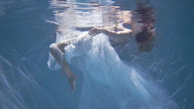 穿着白色裙子的长发女孩漂浮在水下视频素材