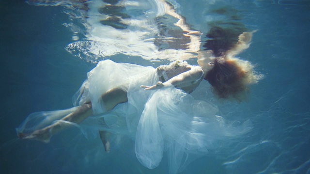 穿着白色裙子的长发女孩漂浮在水下视频素材