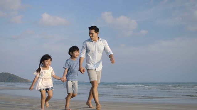 快乐的父亲和他的孩子享受和走在海滩上的暑假。缓慢的运动。家庭，假期和旅游的概念。视频素材