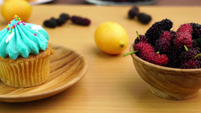 美味的纸杯蛋糕放在木盘子里，配上桑椹和梅子视频素材
