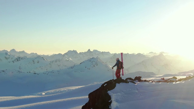 空中盘旋拍摄的滑雪者在雪山的边缘视频素材