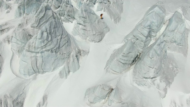 一个滑雪者从高加索山脉的山坡上下来的航拍照片视频下载