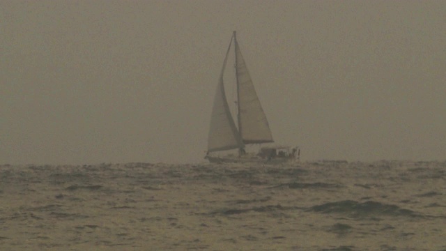 这艘双体帆船正穿行在海上的暴风雨中。视频素材