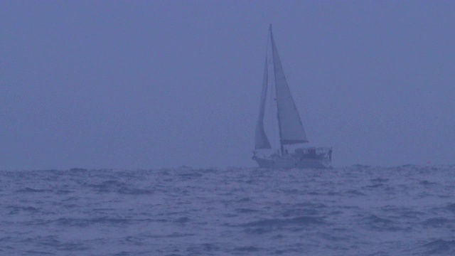 这艘双体帆船正穿行在海上的暴风雨中。视频素材