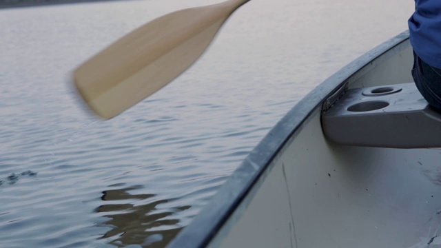 黄昏时分，一个年轻人在英格兰南岸平静的水面上划独木舟视频素材