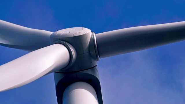 特写的风力涡轮机转子叶片旋转的蓝天背景视频素材