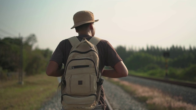 男性背包客在铁路上行走的特写视频下载