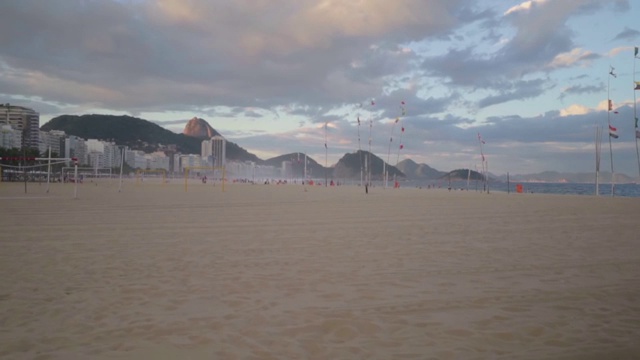 慢镜头:一个黄昏的沙滩，旗帜在风中飘扬视频素材