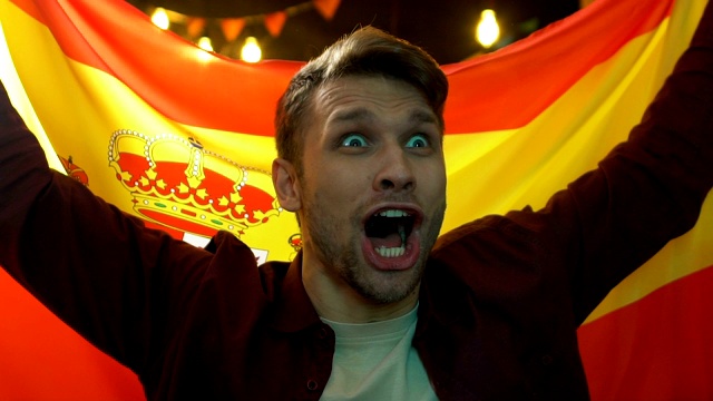 兴奋的球迷挥舞着西班牙国旗在酒吧，庆祝国家队的胜利视频素材