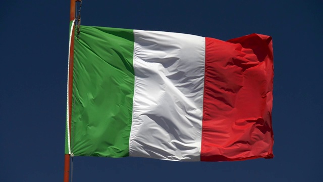 蓝天背景下飘扬的意大利国旗的慢动作镜头。视频素材