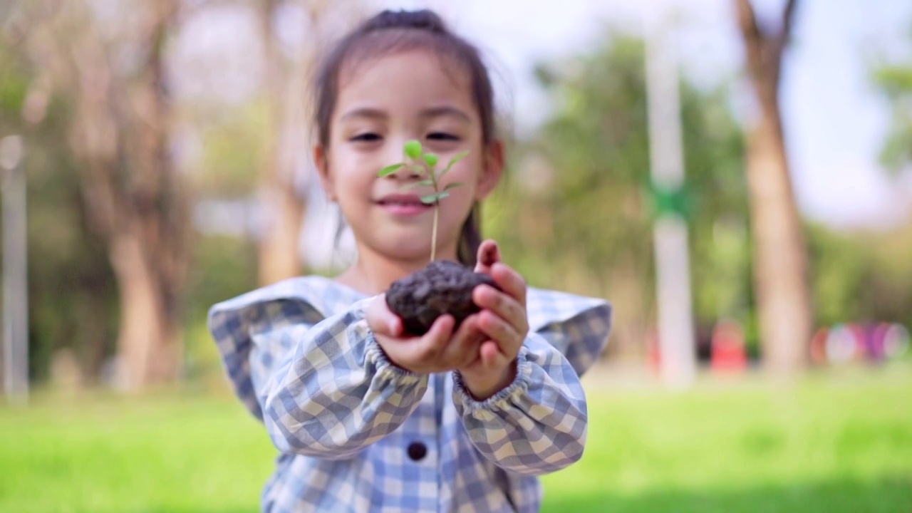 可爱的小亚洲女孩把小植物送给妈妈，拯救地球的理念。视频素材