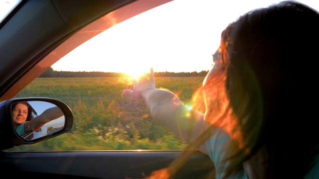 快乐的年轻女人在车和手在空气中玩日落射线视频下载