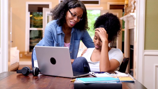 成熟的妈妈帮助压力大的女儿完成大学作业视频素材