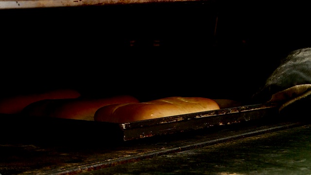 面包店的一个工人做起司蛋糕派，然后在烤箱里烤视频素材