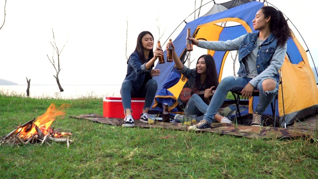 特写镜头:三个女人花周末时间在海边露营日落视频素材