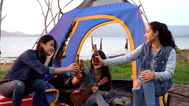 特写镜头:三个女人花周末时间在海边露营日落视频素材