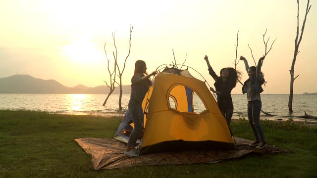 三个年轻女子成功地在周末搭起帐篷去露营视频素材