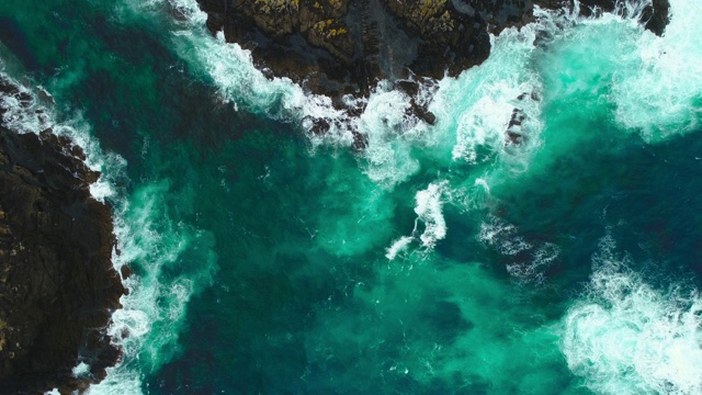 猛烈的海浪拍打岩石的鸟瞰图。视频下载