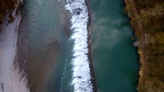 无人机拍摄了瑞士一条阿尔卑斯河流经一片林地的画面。视频素材