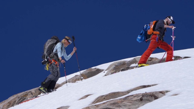 一群滑雪者爬山的慢动作镜头视频下载