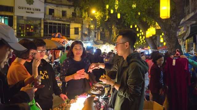 越南人在购买春节装饰品。越南春节期间的河内夜市街。庆祝新年的装饰品。还剑老城区视频素材