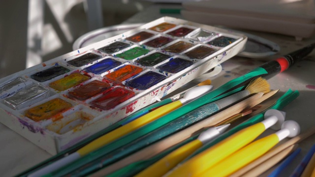 画室的桌面上放着许多绘画用的画笔和调色板视频下载