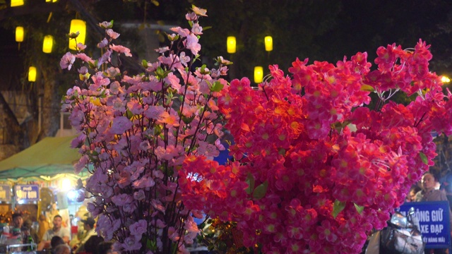 粉红色的花合起来了。新年准备期间，河内的街头市场。越南春节期间的河内夜市街。庆祝新年的装饰品。还剑老城区视频素材