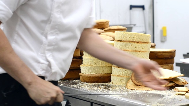 糕点师将海绵蛋糕层层切开。蛋糕生产过程。视频下载