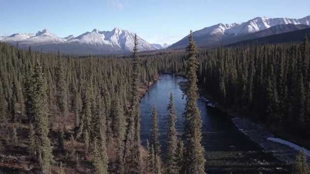 空中飞过原始的荒野河流和美丽的雪山在背景视频素材