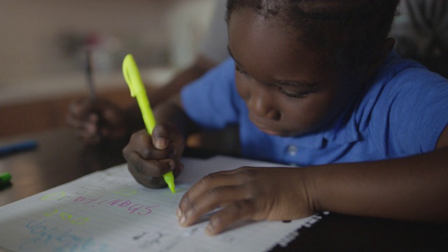 铜。一个年轻的非洲裔美国男孩在他骄傲的妈妈的注视和鼓励下练习写字和画形状。视频下载