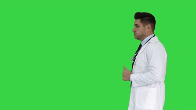 走着的男医生在绿屏上经过，色度钥匙视频素材