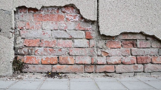 老房子或建筑物地基不良，墙面灰泥开裂，背景为砖视频下载