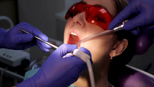 牙科医生在诊所为女病人治疗牙齿。视频素材