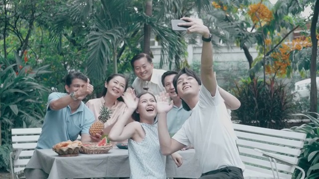 视频会议问候:泰国家庭在后院烧烤派对后用手机自拍视频素材