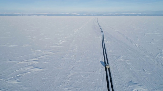 无人机跟踪一辆在冰上行驶的汽车。美丽的冬天的风景视频素材