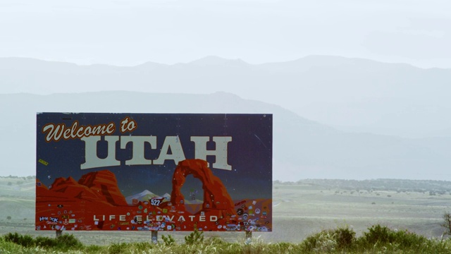 “欢迎来到犹他州”在犹他州/科罗拉多州边境(犹他州东部)70号州际公路上的背景山视频素材