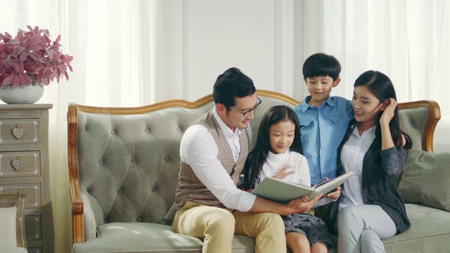 亚洲母亲和父亲读书与儿子和女儿在家里视频素材