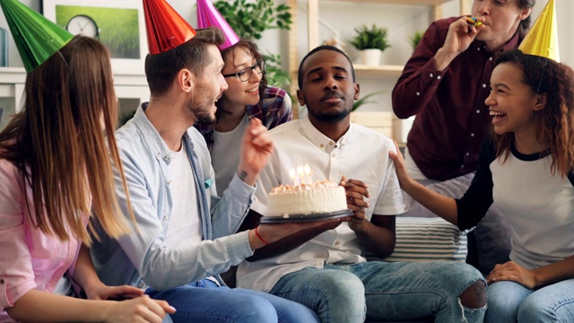 快乐的非裔美国人吹蜡烛在生日蛋糕在家里笑视频素材