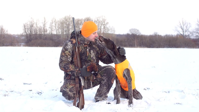 一个愉快的人正在感谢他的狗在打猎时的帮助视频下载