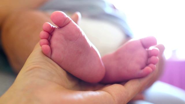 婴儿的脚在妈妈的手里视频素材