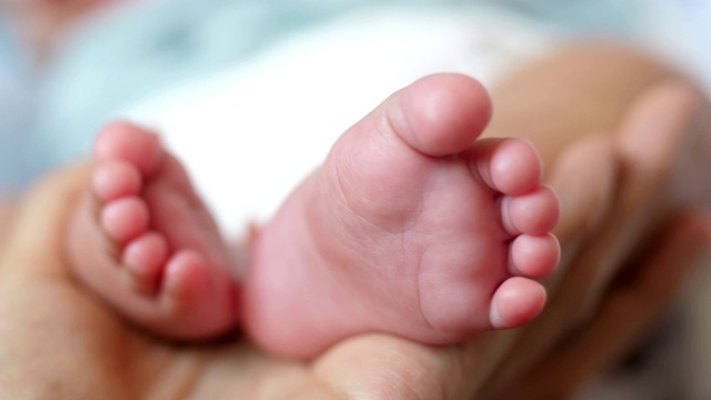 婴儿的脚在妈妈的手里视频素材