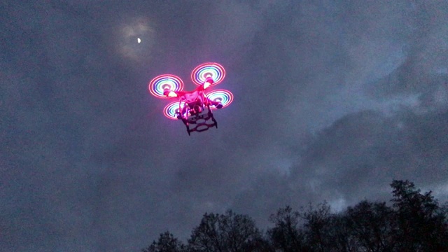 夜间飞行的四轴飞行器和发光的螺旋桨视频下载