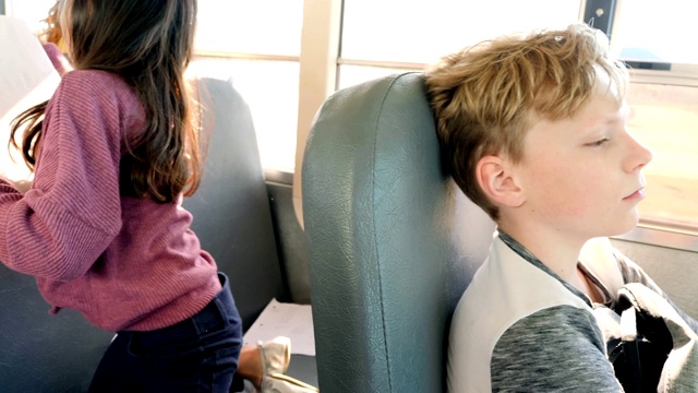 悲伤的小男生坐在校车上视频下载