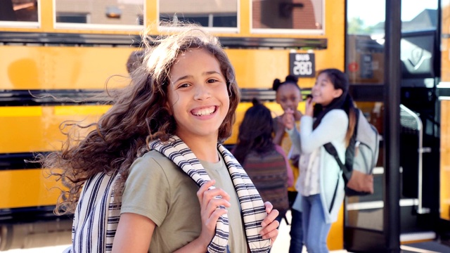 兴奋的女学生准备登上公共汽车的第一天的学校视频素材