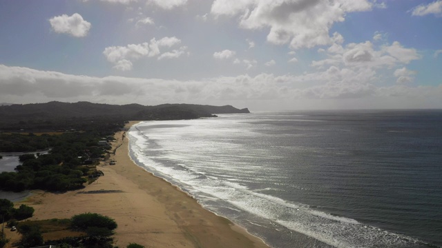 空中攀登:森林覆盖平原，山丘上的沙滩上的蓝色海浪-尼加拉瓜的小玉米岛视频素材